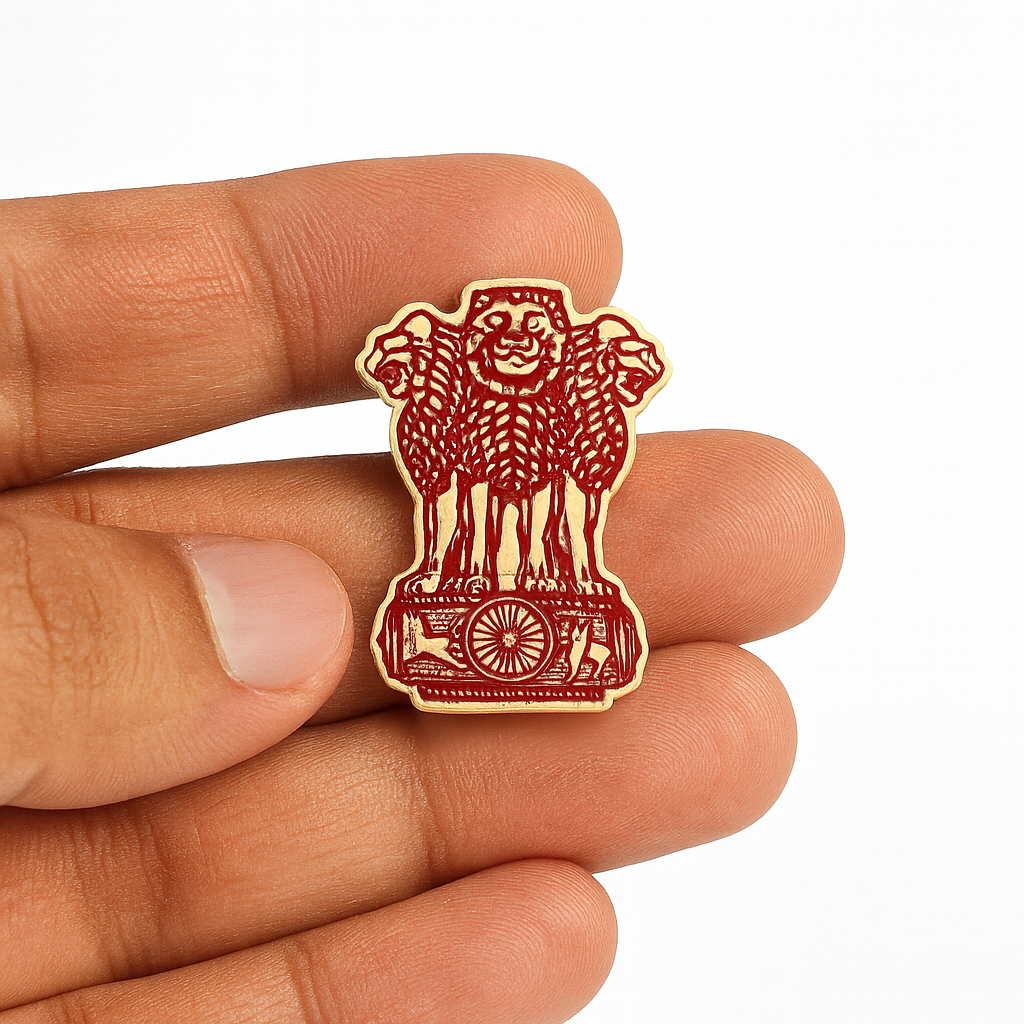 Small red and gold emblem held between fingers on a white background