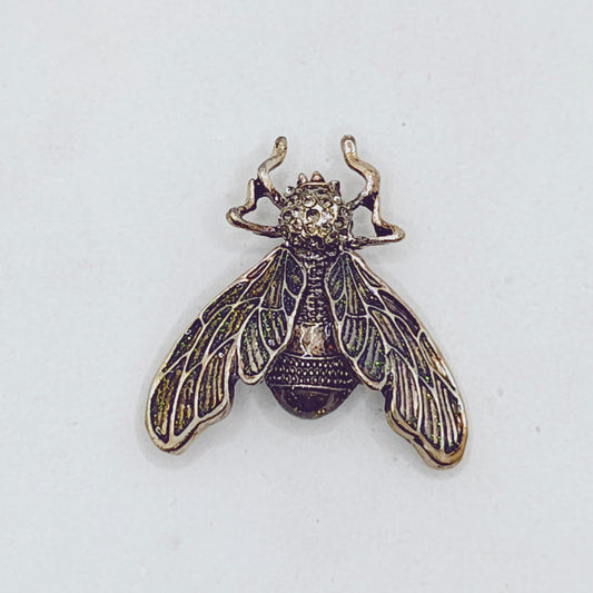 Bronze bee-shaped pin on a white background