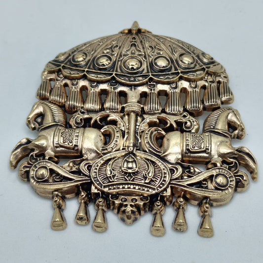 Decorative bronze headpiece with intricate designs on a light gray background