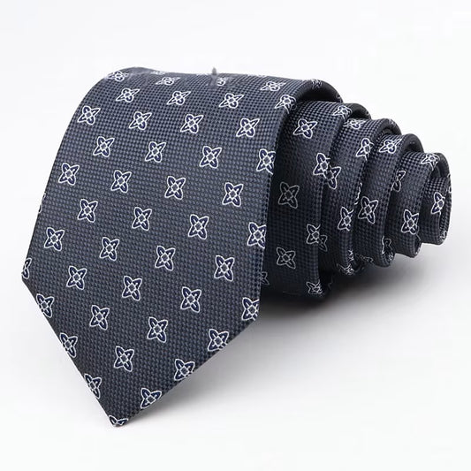 Navy blue tie with white geometric pattern on a light gray background