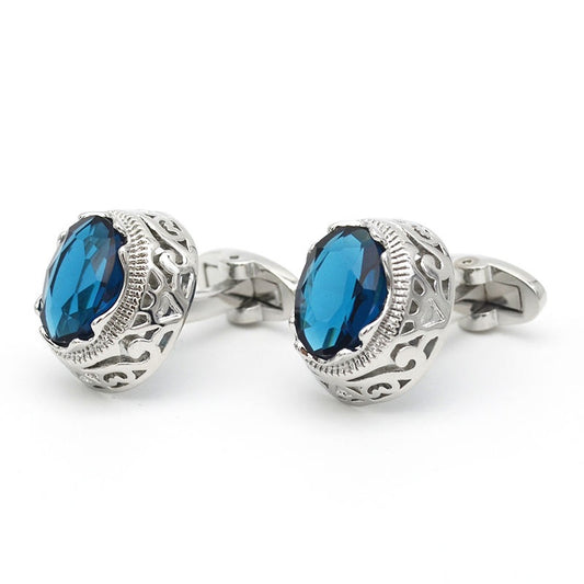 Silver cufflinks with blue gemstones on a white background