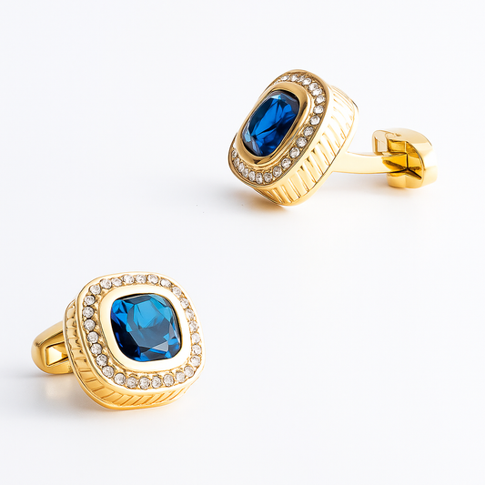 Gold cufflinks with blue gemstones on a white background