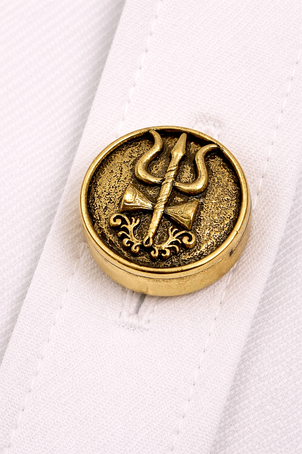 Gold trident symbol on a white fabric background