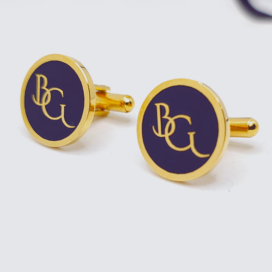 Gold cufflinks with purple circular design and 'BC' initials on a white background
