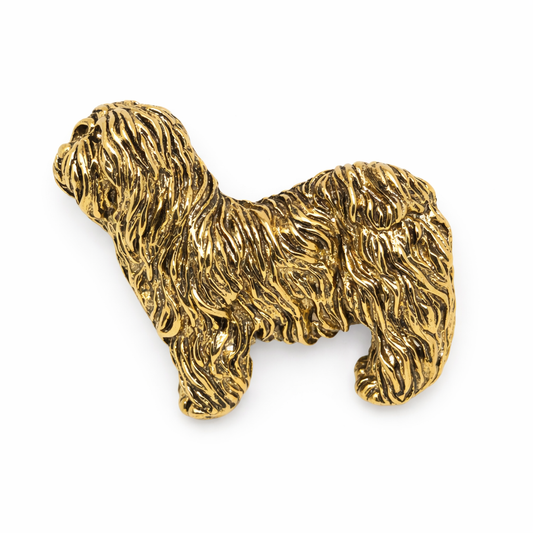 Gold dog-shaped brooch on a white background