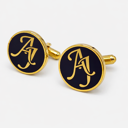 Gold cufflinks with a monogram on a white background