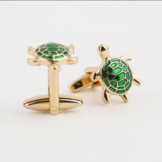 Gold turtle cufflinks with green shell on a white background
