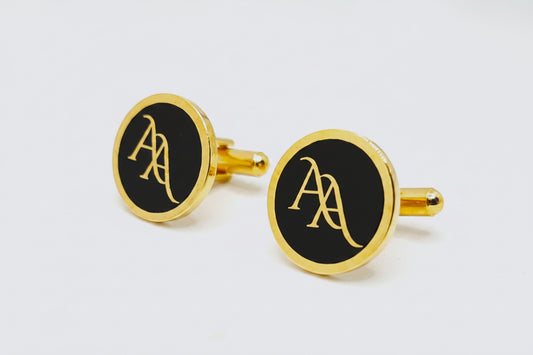 Gold cufflinks with a blue circular design on a white background