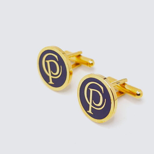 Gold and navy blue cufflinks with a logo on a white background
