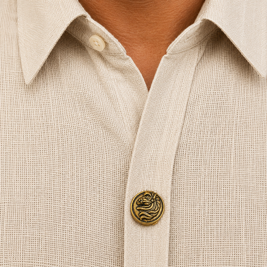 Close-up of a beige shirt with a decorative button featuring a dragon design.