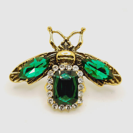 Gold brooch with green gemstones 