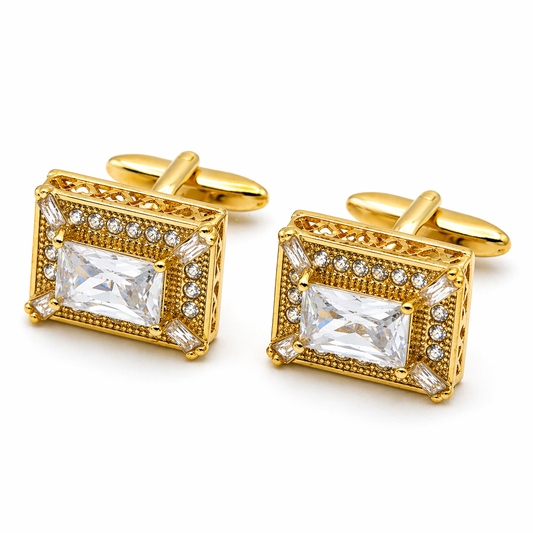 Gold cufflinks with clear gemstones on a white background