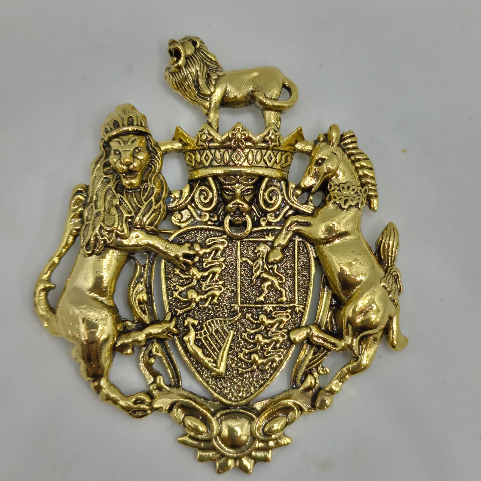 Gold emblem with a lion, unicorn, and shield on a gray background