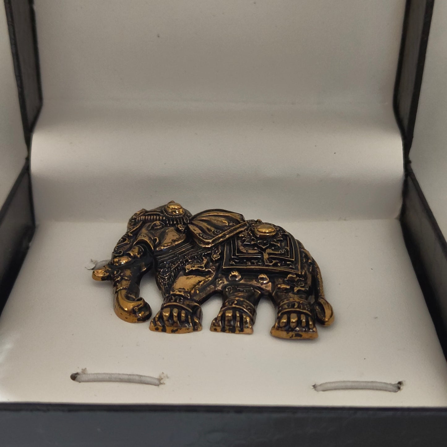 Decorative gold elephant emblem on a white background