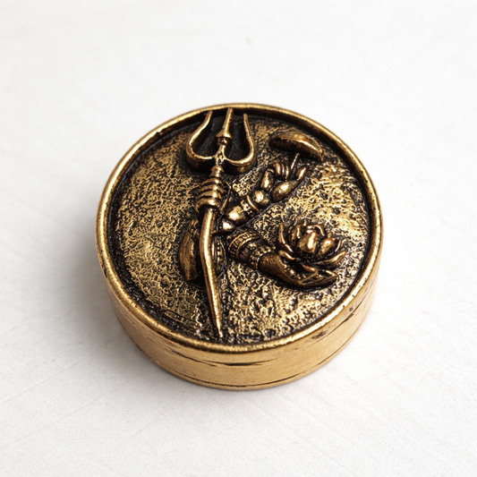 Bronze-colored decorative item with a face holding a trident on a white background