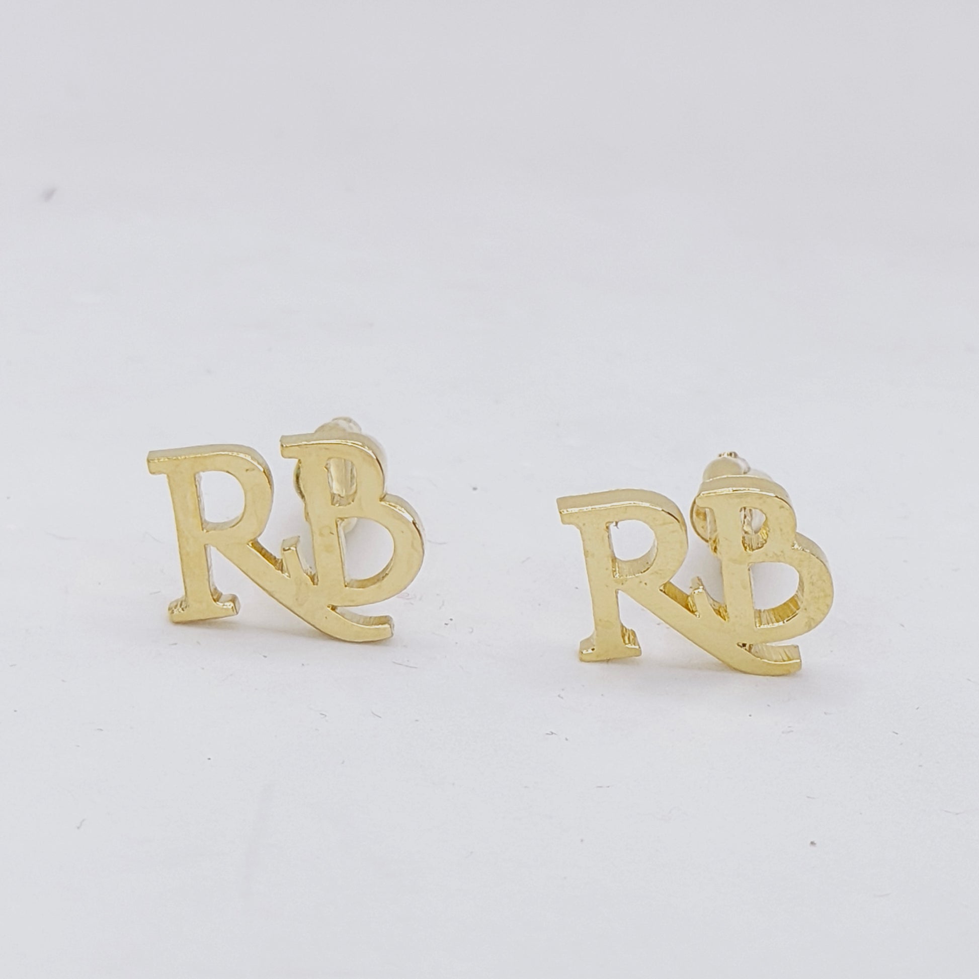 A pair of gold-plated brass cufflinks with the double initial letter RB.