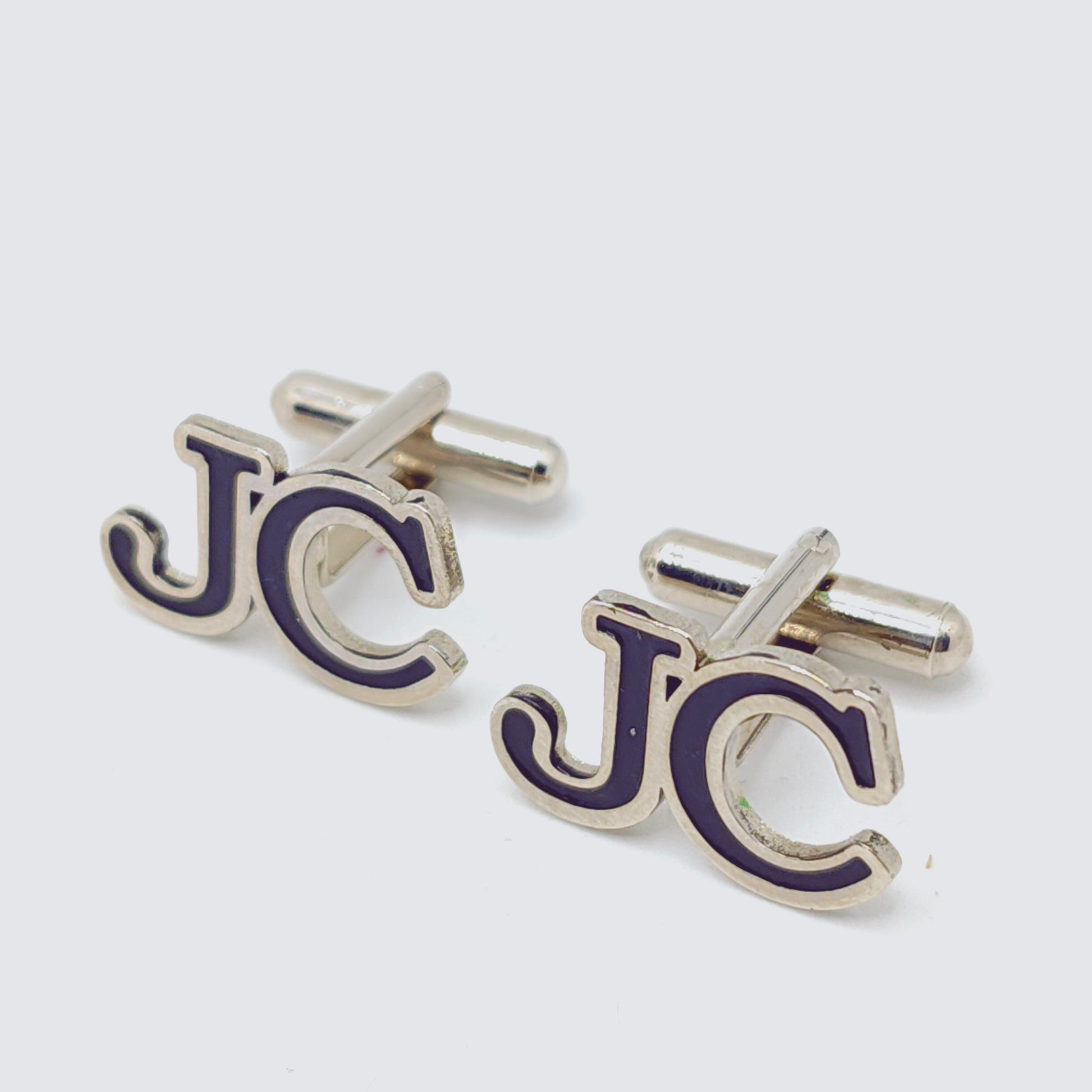 Silver and purple cufflinks on a white background