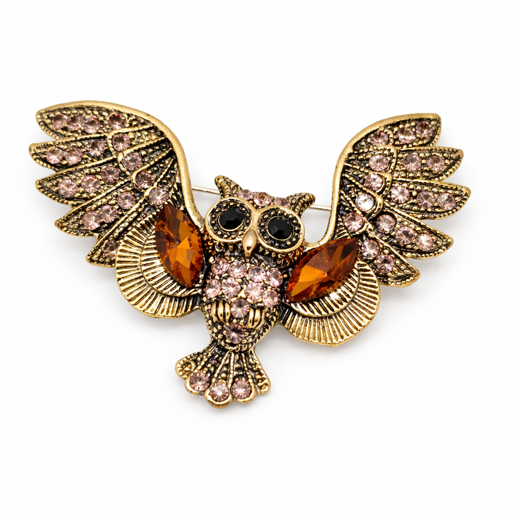 Decorative owl brooch with gemstones on a white background
